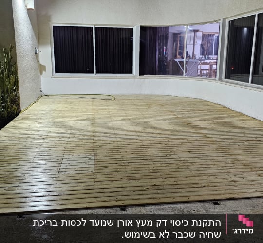 דק עץ מותקן בחצר עם קקטוסים מסביב